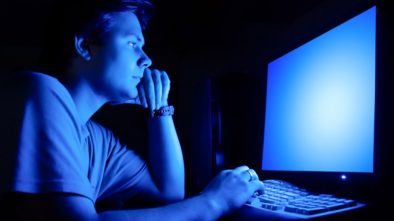 Man Staring at Blue Light Computer Screen